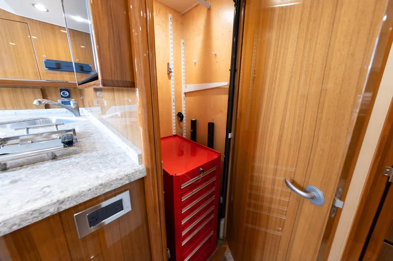 Slide: The Image of Interior of 2017 Viking 52 Sport Tower with red tool chest and wooden cabinetry. - 61