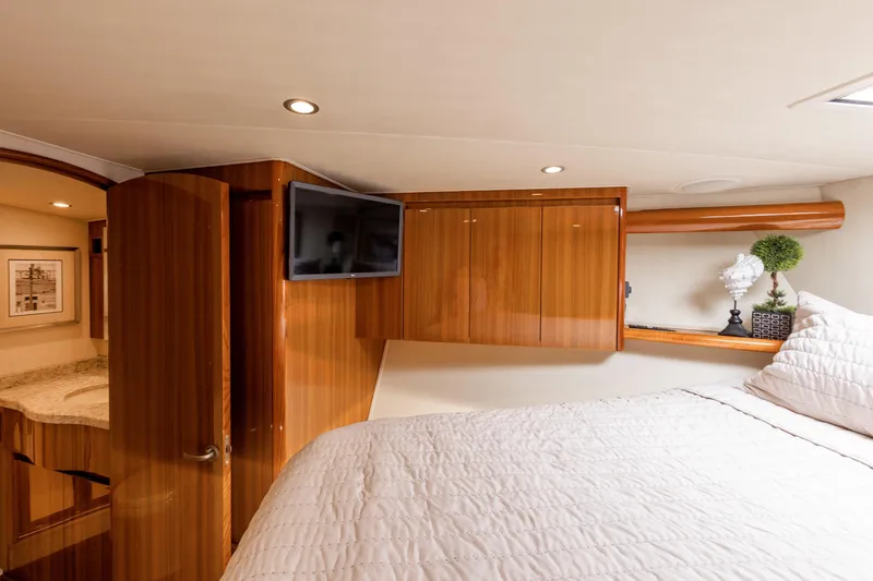 Slide: The Image of Luxurious interior of 2017 Viking 52 Sport Tower yacht with wood finishes and cozy bedding. - 64