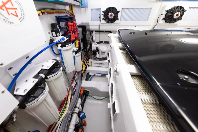 Slide: The Image of Engine room of 2017 Viking 52 Sport Tower with filters, wiring, and ventilation fans. - 87