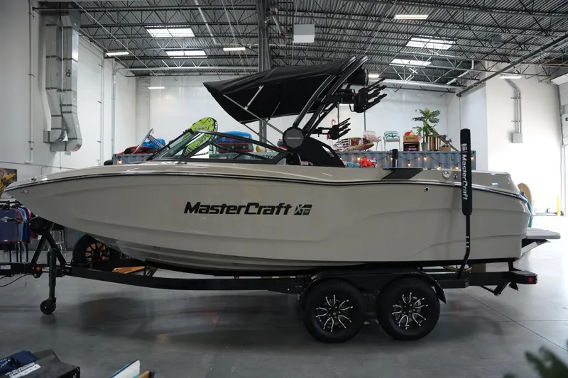 Slide: The Image of 2025 MasterCraft XT22 boat in showroom, side view on trailer. - 1