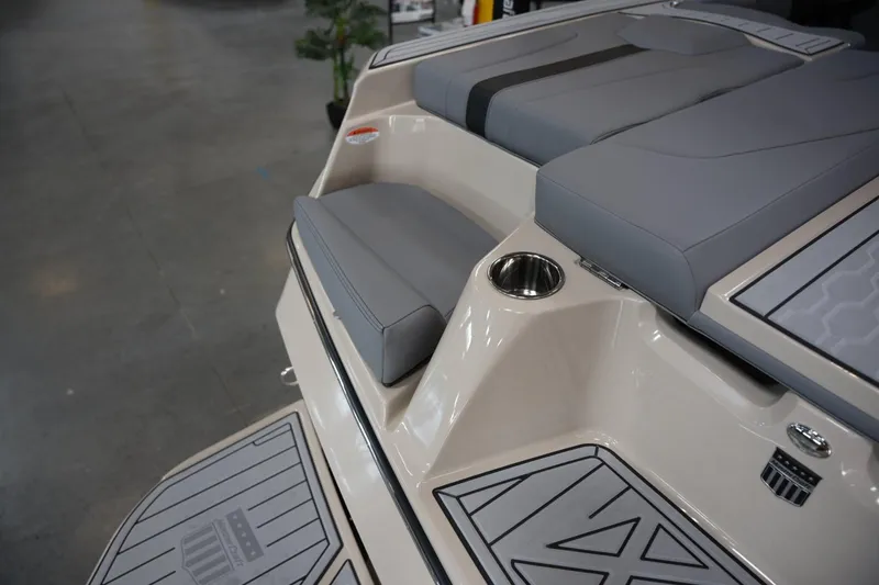 Slide: The Image of 2025 MasterCraft XT22 boat interior with gray seating and cup holder. - 15