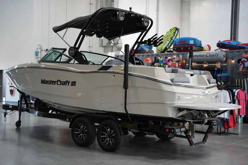 Slide: The Image of 2025 MasterCraft XT22 boat on trailer in showroom setting. - 2