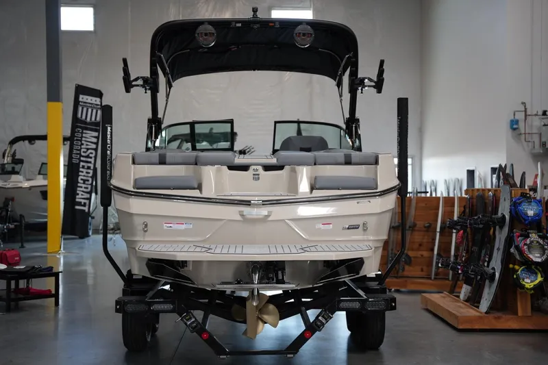 Slide: The Image of 2025 MasterCraft XT22 boat displayed in showroom with wakeboards and accessories. - 3