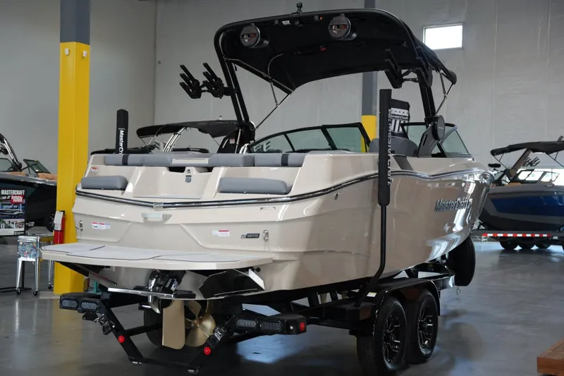 Slide: The Image of 2025 MasterCraft XT22 boat on trailer in showroom, rear view. - 4