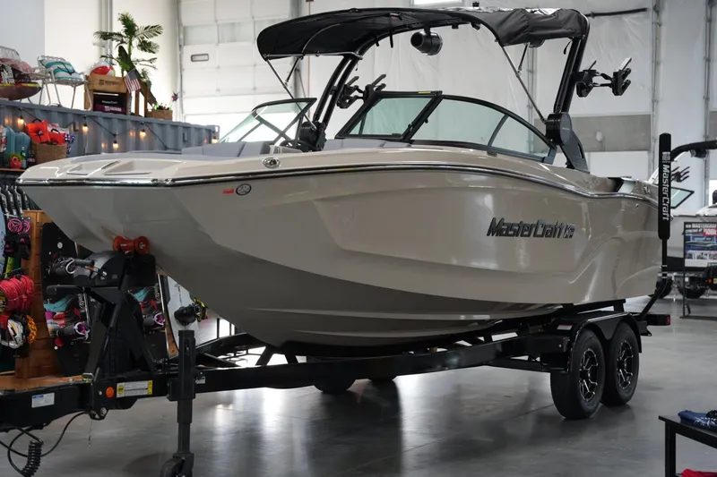 Slide: The Image of 2025 MasterCraft XT22 boat on trailer in showroom setting. - 7