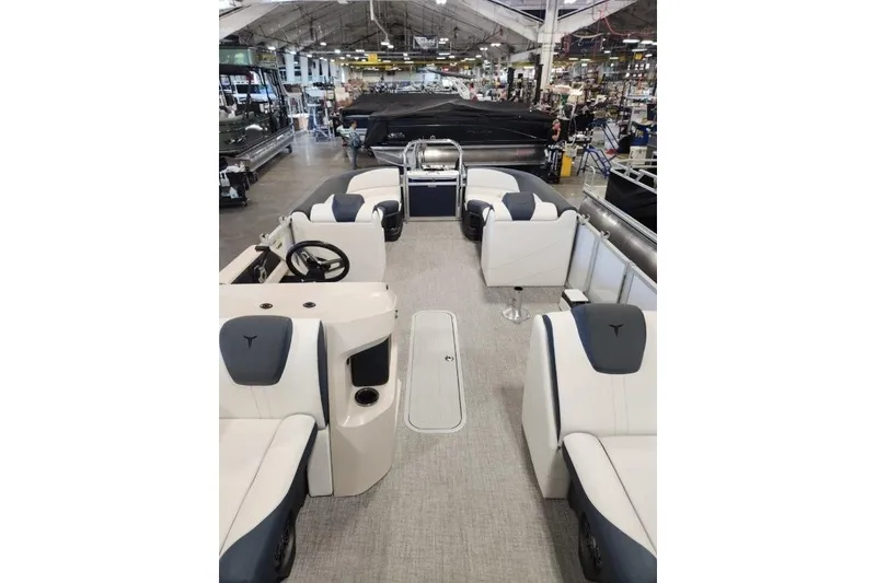 Slide: The Image of 2026 Tahoe Pontoon LTZ Quad Lounger 23 interior with spacious seating in showroom. - 4