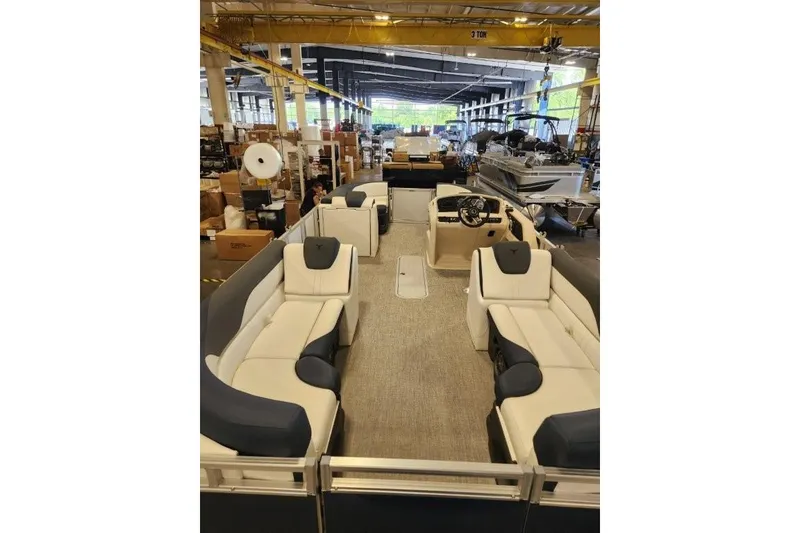 Slide: The Image of 2026 Tahoe Pontoon LTZ Quad Lounger 23 in a factory setting, showcasing spacious seating. - 5