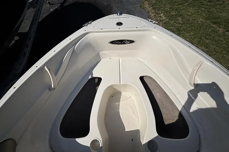 Slide: The Image of Bow seating area of a 2004 Sea Ray 185 Sport boat, featuring white upholstery. - 16