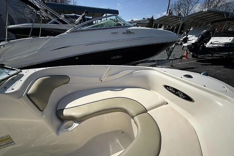Slide: The Image of 2004 Sea Ray 185 Sport boat interior with seating, parked alongside other boats. - 17