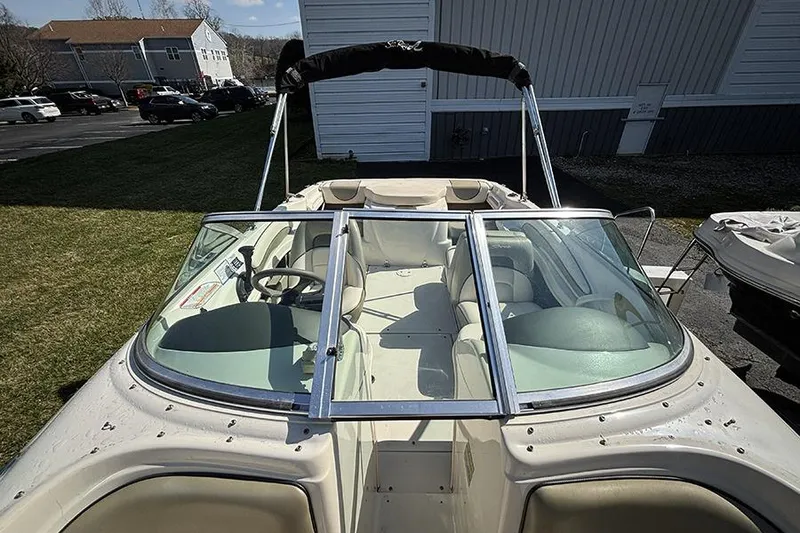 Slide: The Image of 2004 Sea Ray 185 Sport boat with open cockpit and windshield, parked outdoors. - 19