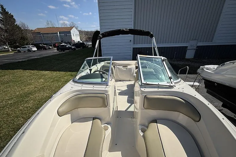 Slide: The Image of 2004 Sea Ray 185 Sport boat with open bow seating and windshield, parked outdoors. - 20