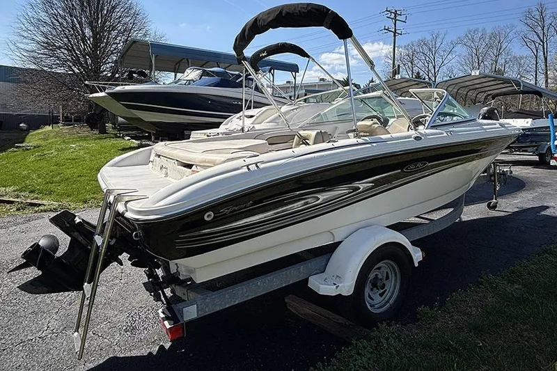 Slide: The Image of 2004 Sea Ray 185 Sport boat on trailer, parked outdoors under clear sky. - 3