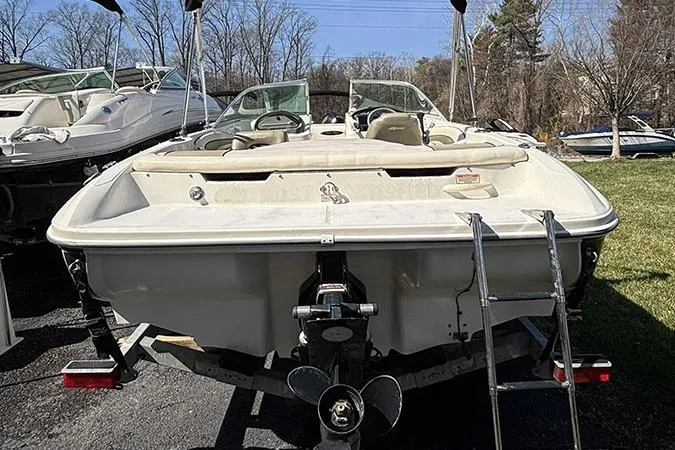 Slide: The Image of 2004 Sea Ray 185 Sport boat with ladder, parked outdoors on a sunny day. - 4