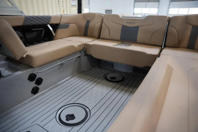Slide: The Image of 2025 MasterCraft XT23 boat interior with beige seating and sleek flooring design. - 10
