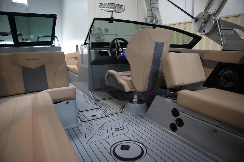 Slide: The Image of Interior of 2025 MasterCraft XT23 boat with beige seating and modern dashboard. - 11