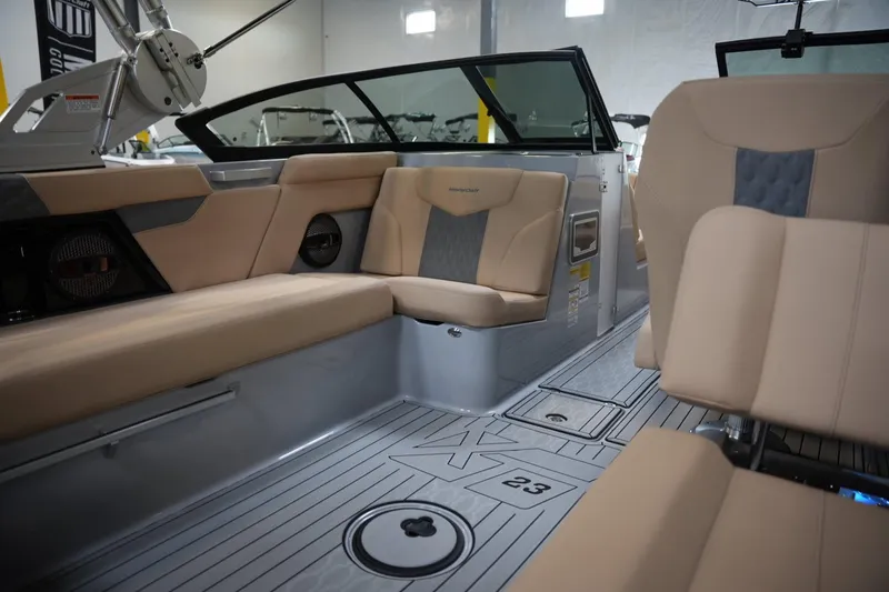 Slide: The Image of 2025 MasterCraft XT23 boat interior with beige seating and sleek design. - 12