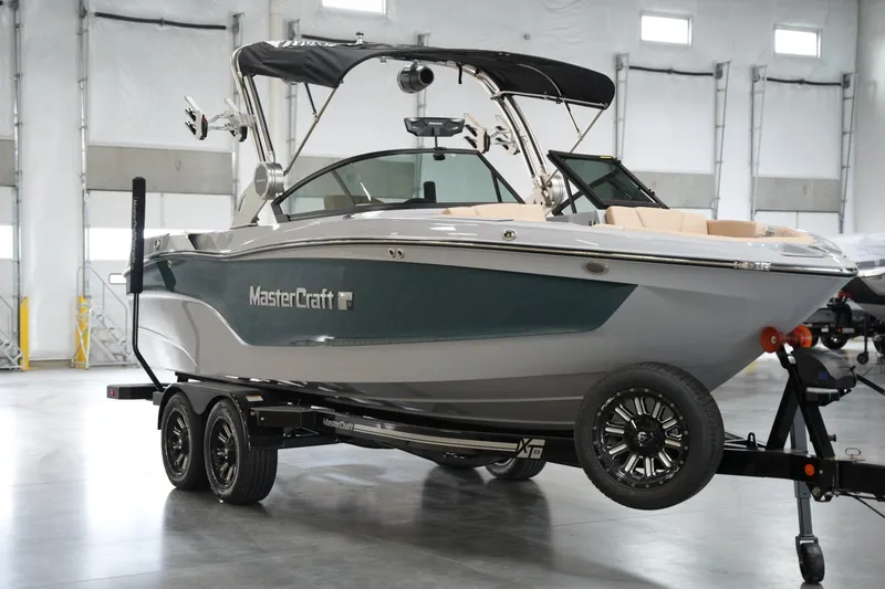 Slide: The Image of 2025 MasterCraft XT23 boat on trailer in indoor showroom. - 3