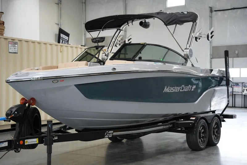 Slide: The Image of 2025 MasterCraft XT23 boat on trailer in indoor showroom. - 4