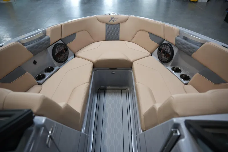 Slide: The Image of 2025 MasterCraft XT23 boat interior with beige seating and built-in speakers. - 5