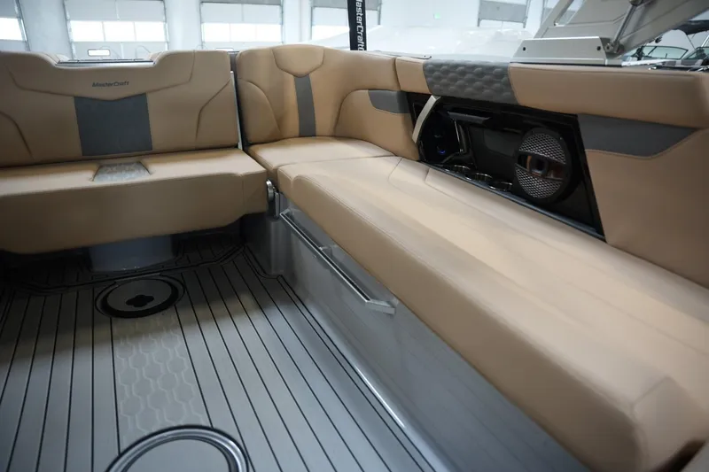 Slide: The Image of 2025 MasterCraft XT23 boat interior with tan seating and modern audio system. - 9
