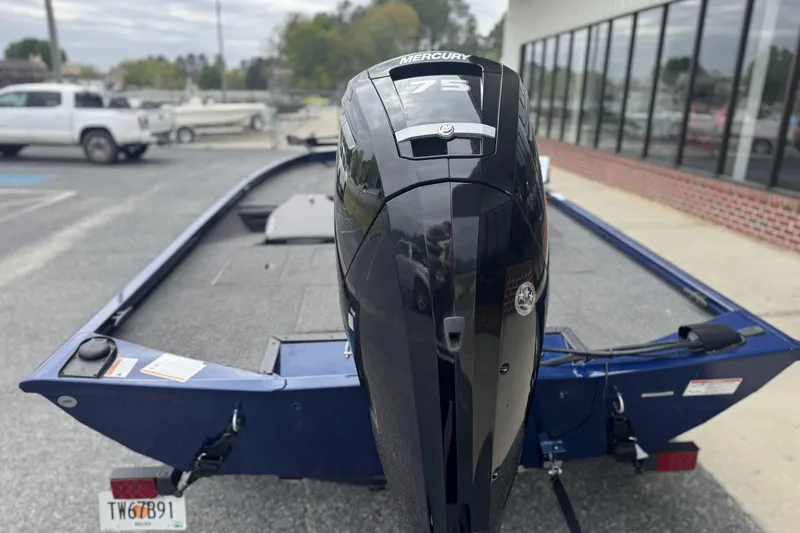 Slide: The Image of 2024 Lowe Stinger 175C boat with Mercury 75 engine, parked outdoors. - 4