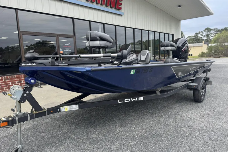 Slide: The Image of 2024 Lowe Stinger 175C boat on trailer, parked outside a building. - 6