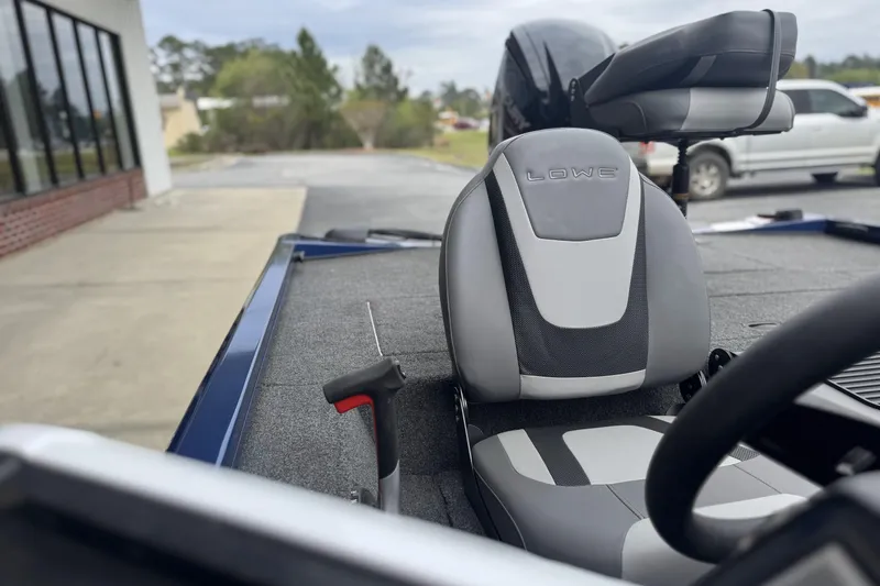 Slide: The Image of 2024 Lowe Stinger 175C boat interior with gray seating and steering wheel. - 9