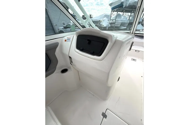 Slide: The Image of 2021 Robalo R247 Dual Console boat interior with storage compartment and seating area. - 11