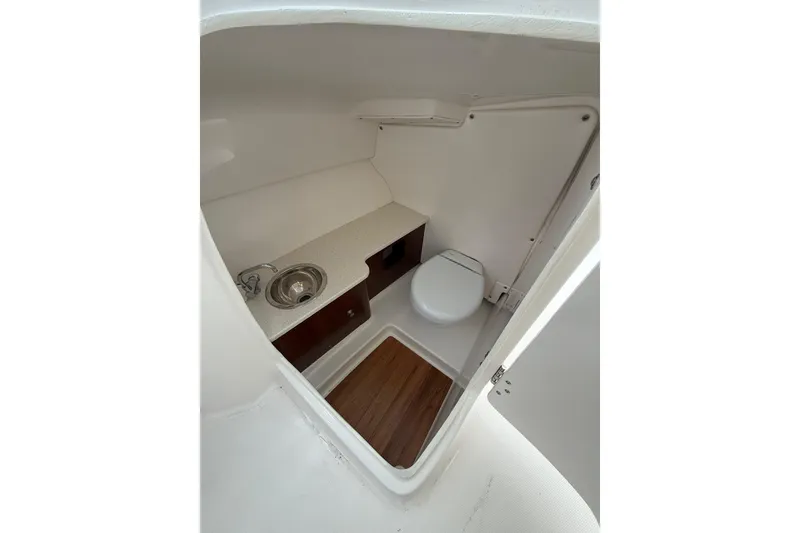 Slide: The Image of 2021 Robalo R247 Dual Console boat interior with sink and toilet. - 12