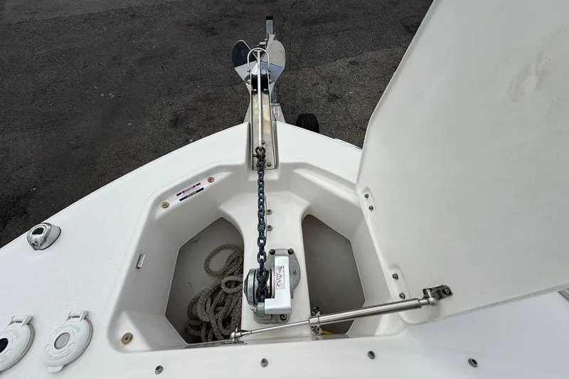Slide: The Image of Anchor compartment of 2021 Robalo R247 Dual Console boat with chain and rope. - 14