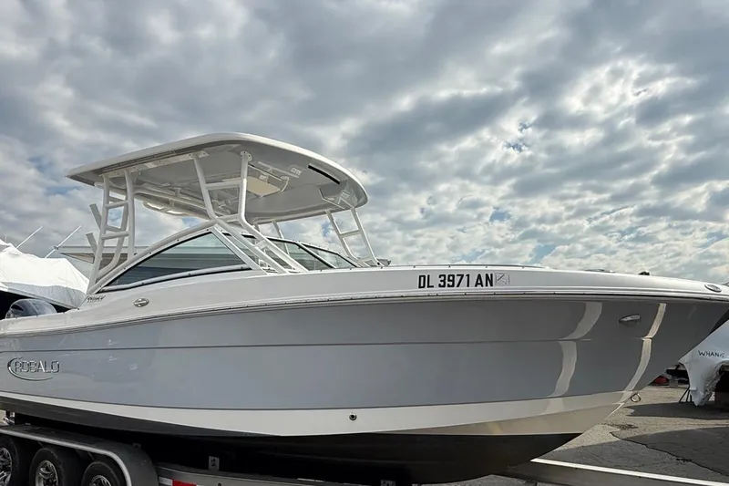 Slide: The Image of 2021 Robalo R247 Dual Console boat on trailer under cloudy sky. - 2