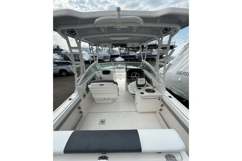 Slide: The Image of 2021 Robalo R247 Dual Console boat interior with seating and helm, docked outdoors. - 6
