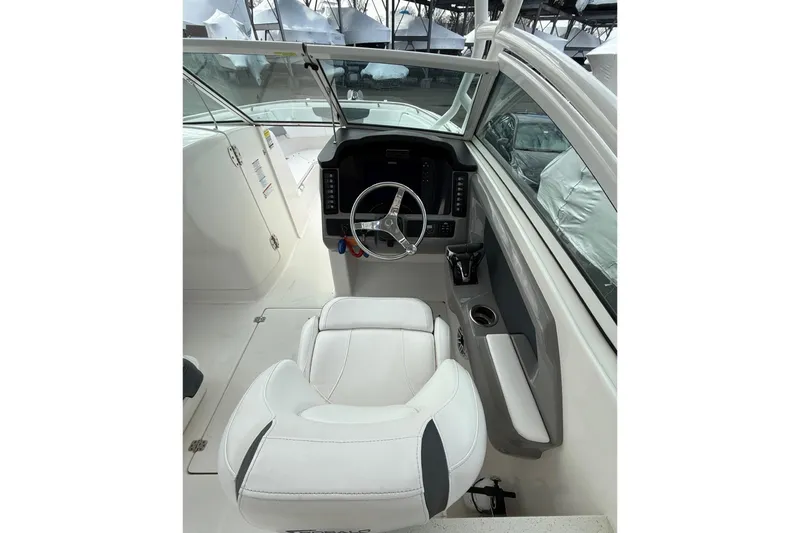 Slide: The Image of 2021 Robalo R247 Dual Console boat interior with steering wheel and white seating. - 8