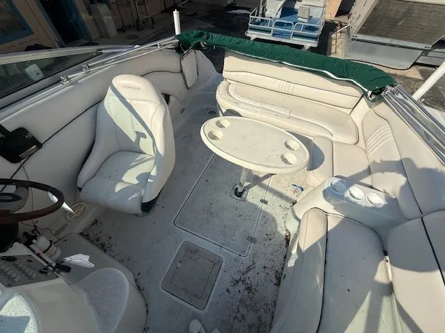 Slide: The Image of Interior of a 2001 Crownline 230 CCR boat with seating area and table. - 2
