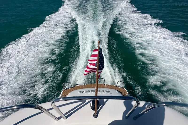 Slide: The Image of Rear view of 2006 Lazzara 68 Motoryacht cruising with American flag waving. - 13