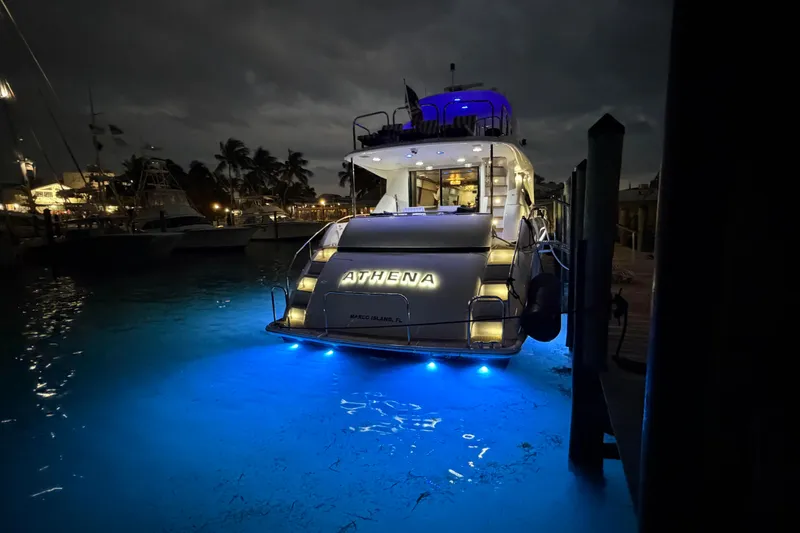 Slide: The Image of 2006 Lazzara 68 Motoryacht docked at night with illuminated name "Athena." - 7
