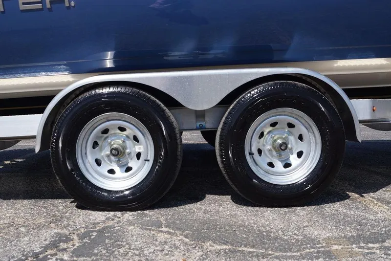 Slide: The Image of Trailer wheels of a 2026 Skeeter SX241 boat on pavement. - 2