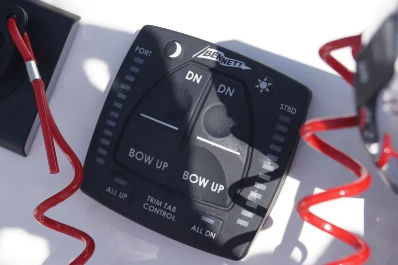 Slide: The Image of Bennett trim tab control panel on 2026 Skeeter SX241 boat, with red safety lanyard. - 23