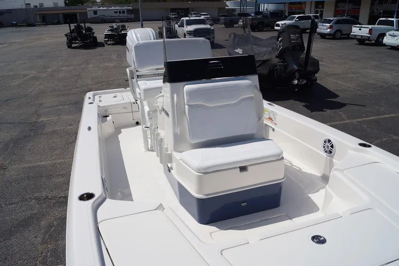 Slide: The Image of 2026 Skeeter SX241 boat interior with white seating and console, parked outdoors. - 33