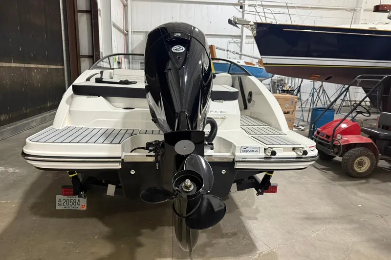 Slide: The Image of 2025 Sea Ray 19 SPX OB boat in a storage facility, rear view with outboard motor. - 6