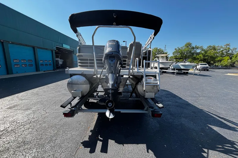 Slide: The Image of 2023 Bennington 188SLJ pontoon boat with outboard motor, parked outdoors. - 4