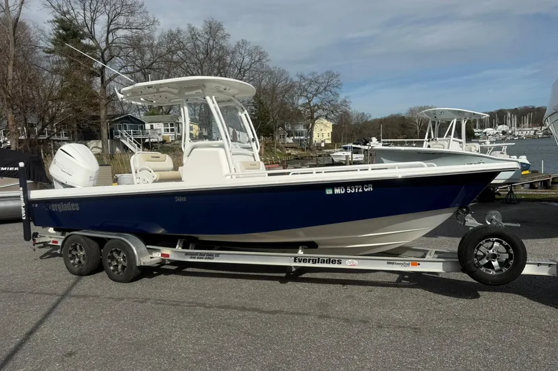The Image of 2016 Everglades 243 Center Console boat on trailer, parked near waterfront. - 1