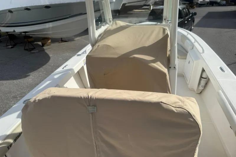 Slide: The Image of 2016 Everglades 243 Center Console boat with covered seating, docked outdoors. - 28