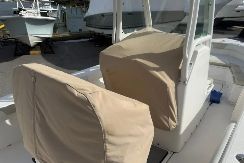 Slide: The Image of 2016 Everglades 243 Center Console boat with covered seats at a marina. - 29