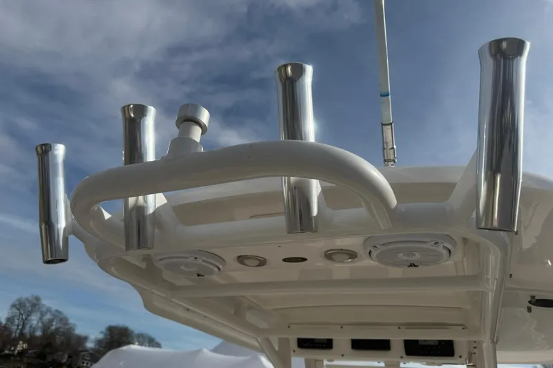 Slide: The Image of 2016 Everglades 243 Center Console boat with rod holders and speakers under blue sky. - 30