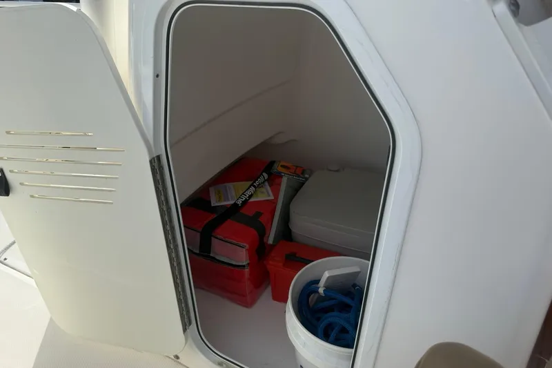 Slide: The Image of Storage compartment on a 2016 Everglades 243 Center Console boat with equipment and supplies. - 32
