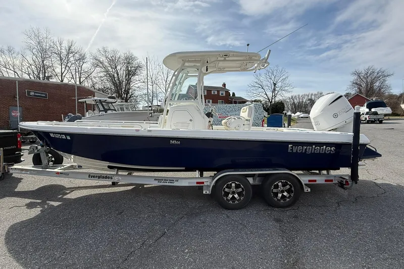 Slide: The Image of 2016 Everglades 243 Center Console boat on trailer, parked outdoors under cloudy sky. - 7