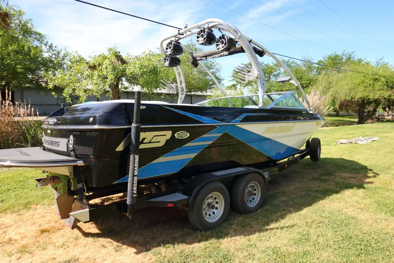 Slide: The Image of 2012 MB B-52 23 Widebody boat on trailer, parked on grass. - 3