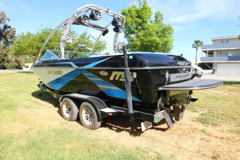 Slide: The Image of 2012 MB B-52 23 Widebody boat on trailer, featuring sleek design and vibrant graphics. - 6