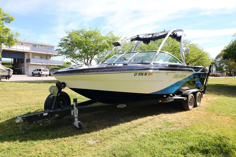 Slide: The Image of 2012 MB B-52 23 Widebody boat on trailer, parked on grass. - 7